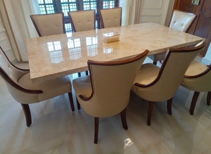 Marble-top dining table with cushioned chairs
