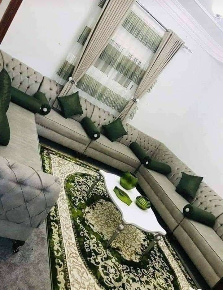 Majlis-style tufted grey sofa with green cushions