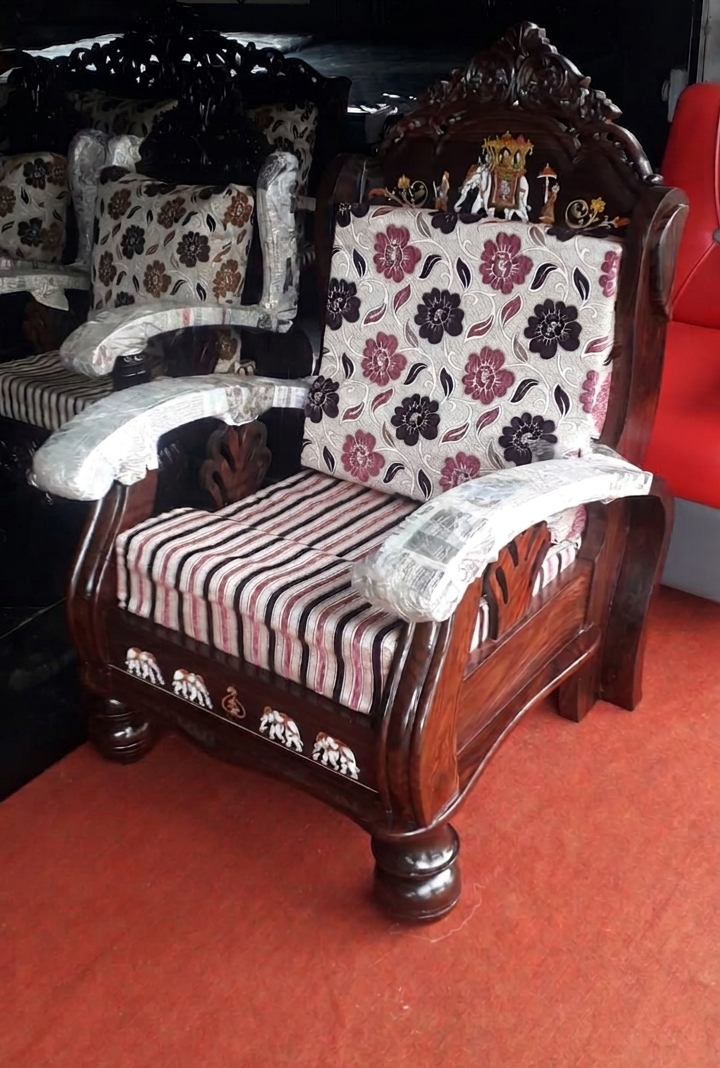 Ornate carved wood armchair with floral cushions